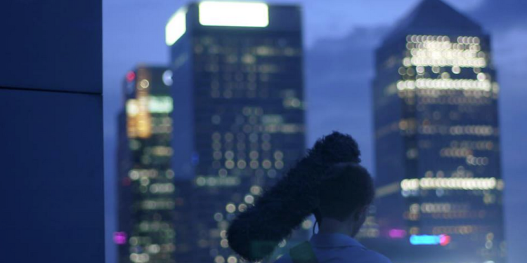 man-with-camera-outside-at-night-with-view-of-london-skyline