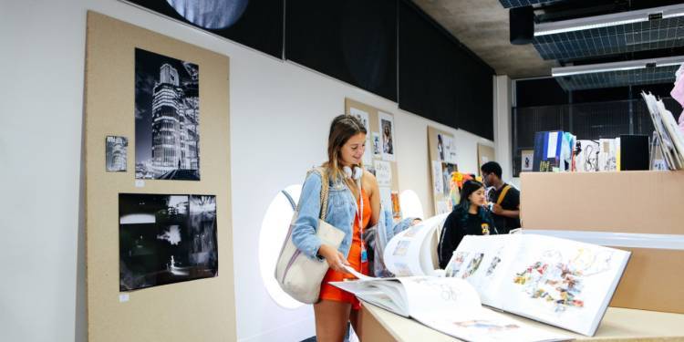 Woman looks through student work on display