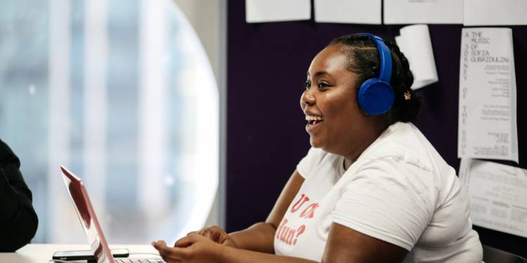 Student smiling sat at laptop