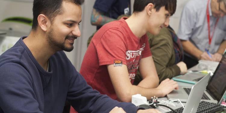 Ravensbourne student sits working at his laptop