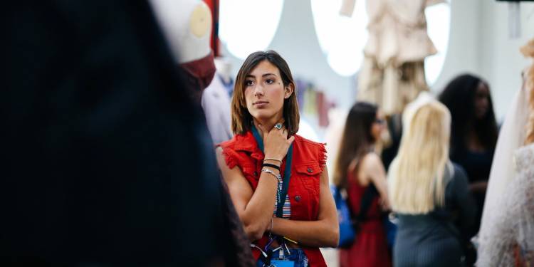 Woman stands observing fashion work