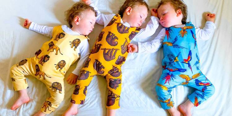 Three babies take a nap wearing Project Panda rompers