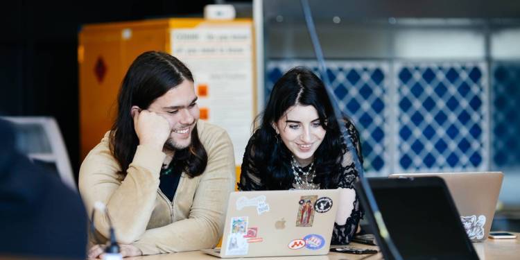 Man and woman smiling and looking at a laptop