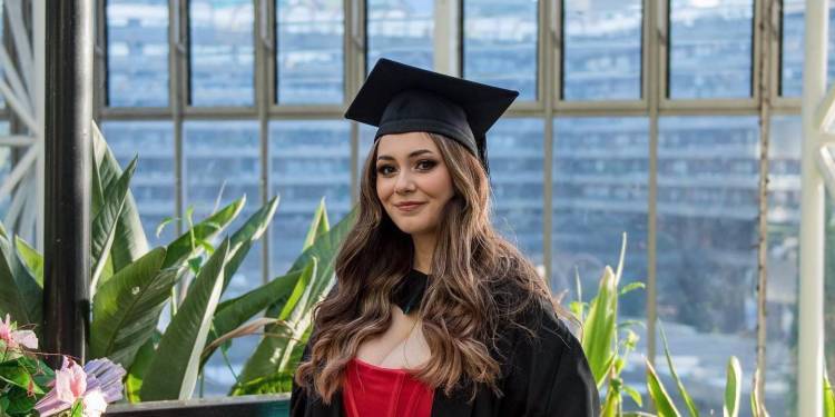 Zahra Shahsavari in a cap and gown and red dress at a graduation ceremony
