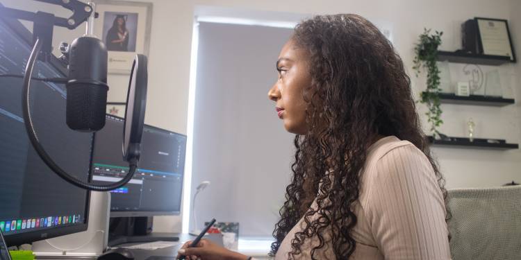 Jasmin operates editing software on her monitor screen