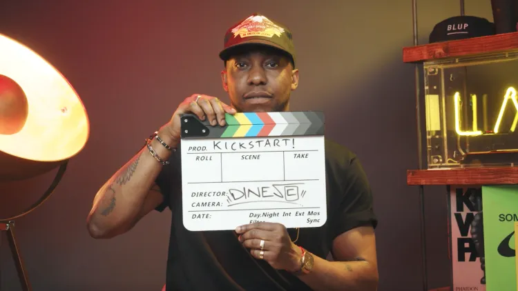 Man wearing a hat holding clapper board