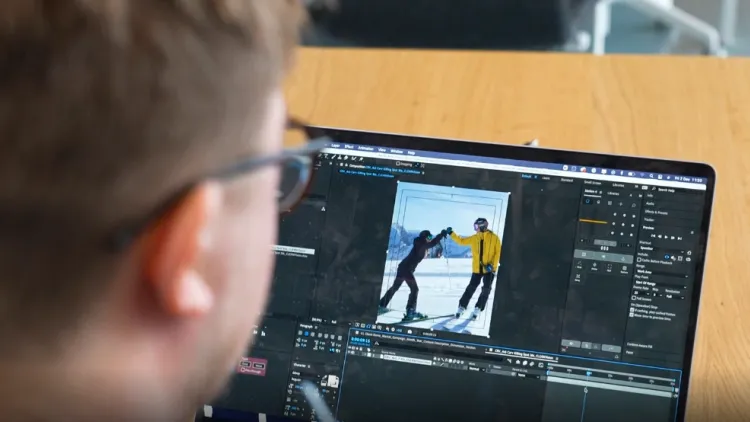 Over the shoulder image of man editing work on his laptop