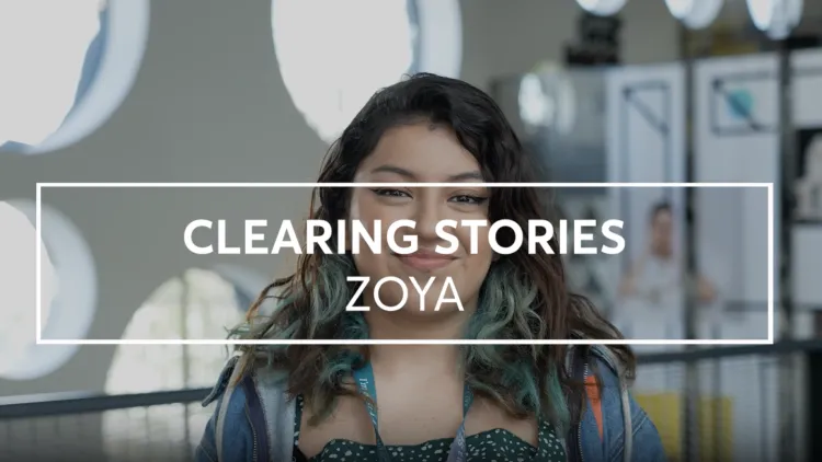 Young woman with dark hair smiles into the camera.