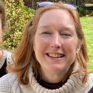 Woman smiling outside with sunglasses on her head