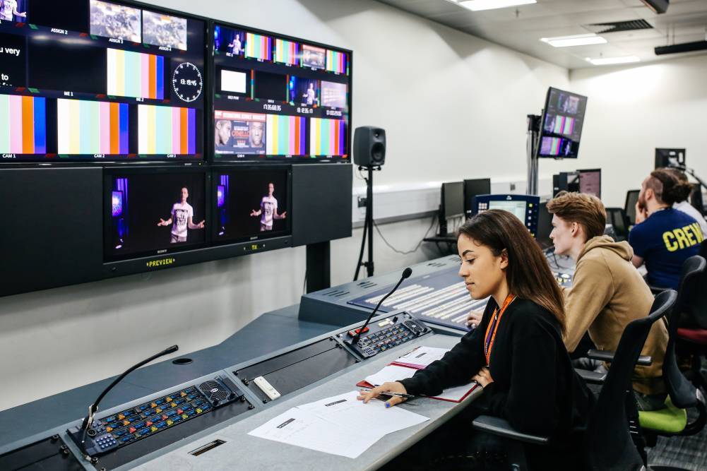 Woman sat in tv gallery in editing studio