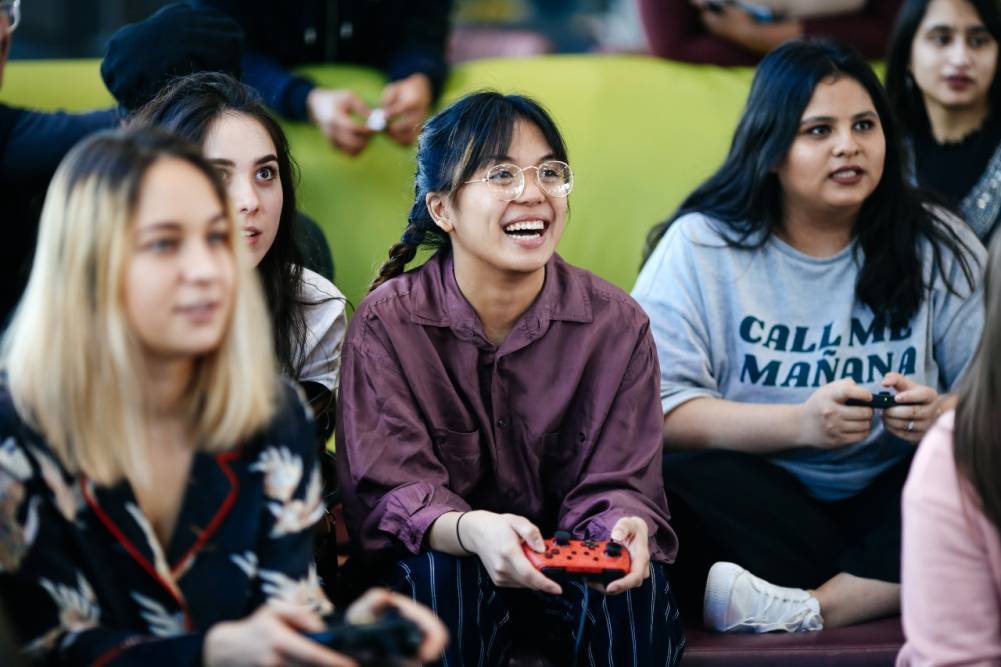 Group of female students playing computer games together