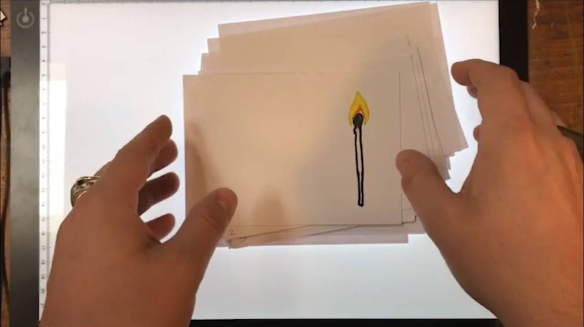 a pair of hands organising a stack of A6 paper with the match burning animation sketched on them