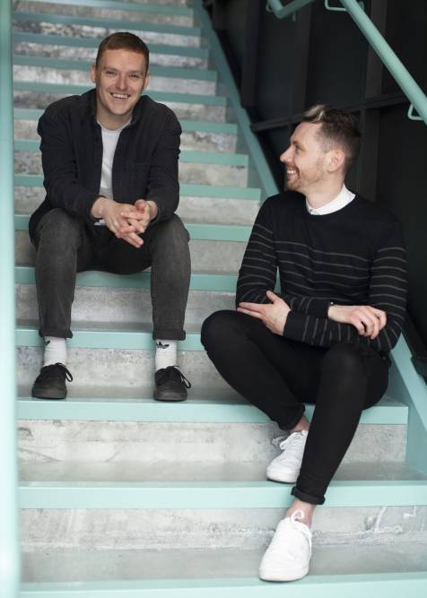 Jack Brown and Lee McMahon laughing together on the stairs