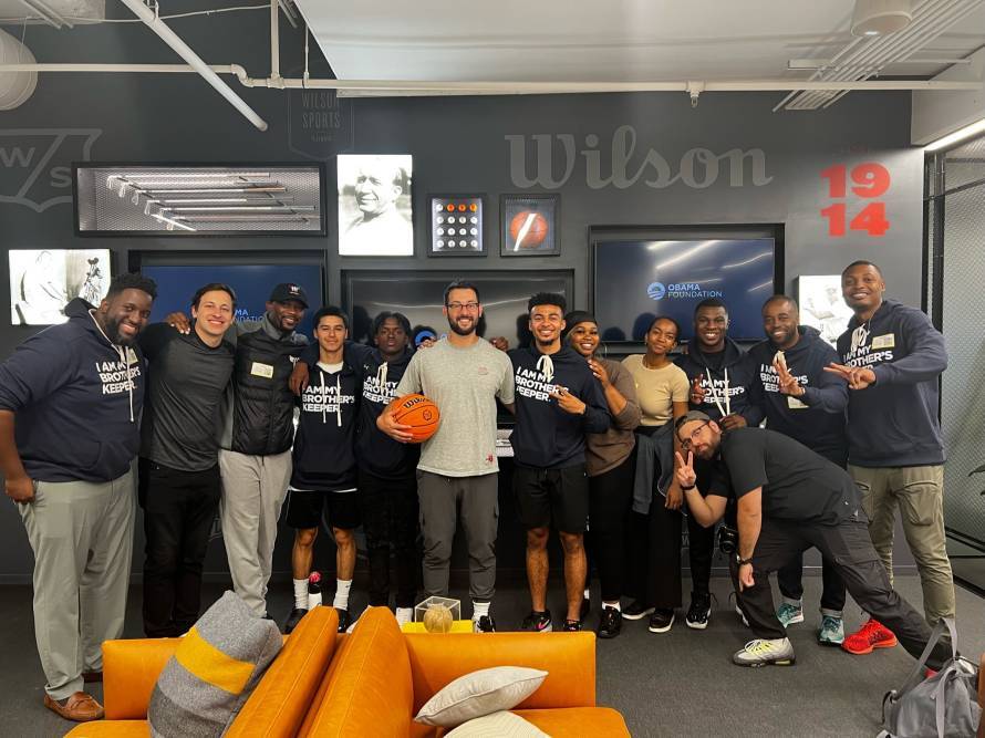 Group of students pose with team at Wilson Basketball office
