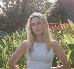 Image of woman stood outside in front of field of tall grass