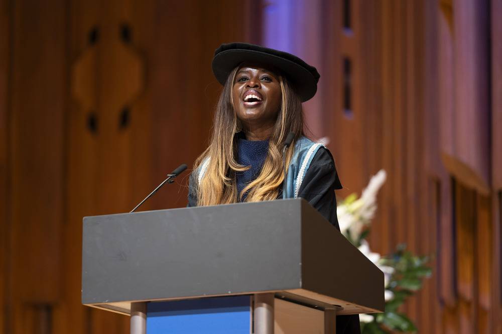 June Sarpong stands on stage addressing audience