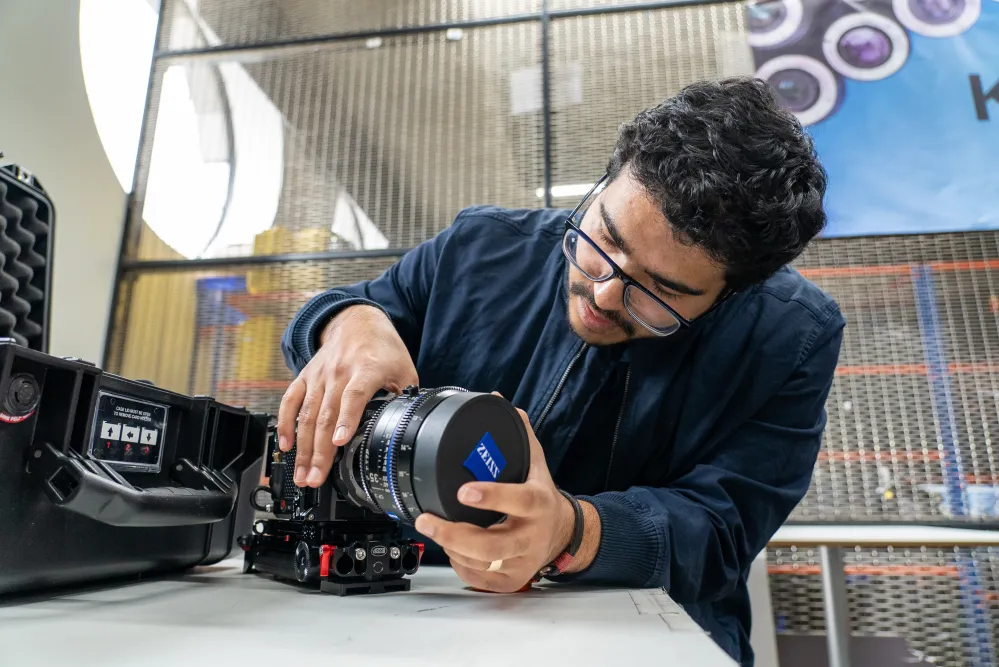 Student fitting Zeiss camera lens to Komodo 6K camera in Ravensbourne's kit store