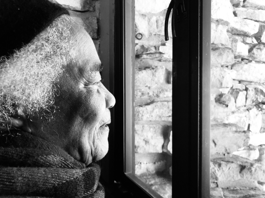 Black and white photo of woman looking out the window