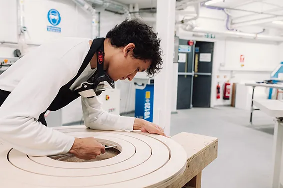 Calum Gambrill carving a rounded wooden structure for The Big Design Challenge