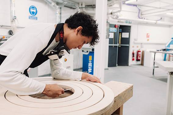 Calum Gambrill carving a rounded wooden structure for The Big Design Challenge