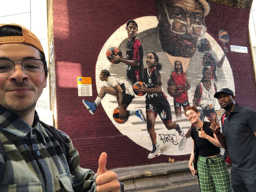 Man poses in front of basketball graffiti scene