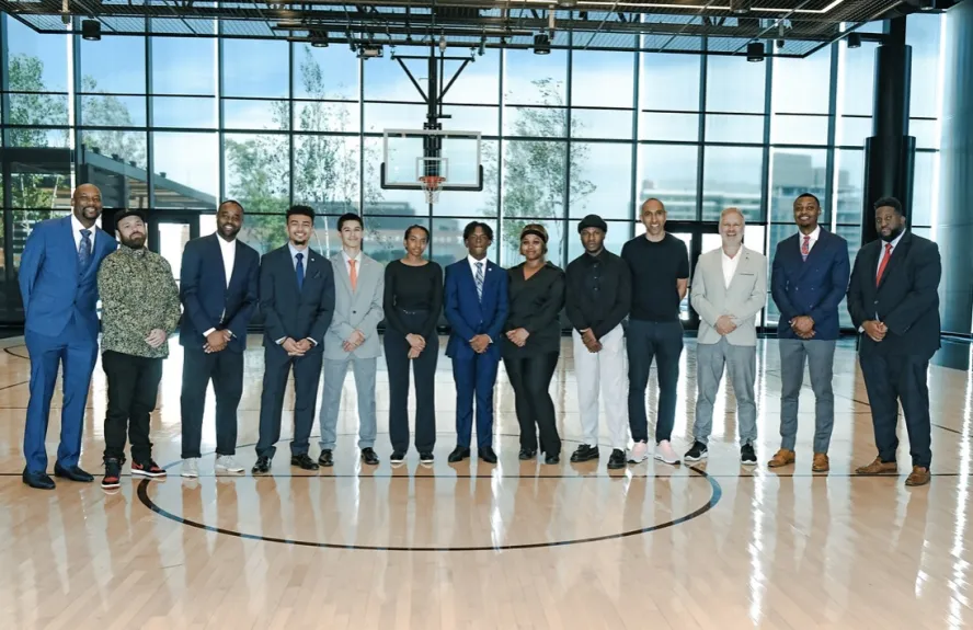 Students from Ravensbourne and MBK Alliance pose on a basketball court in London