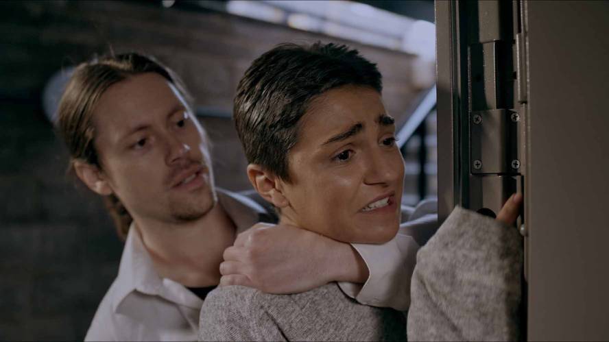 A man grabs a distressed character by their neck from behind