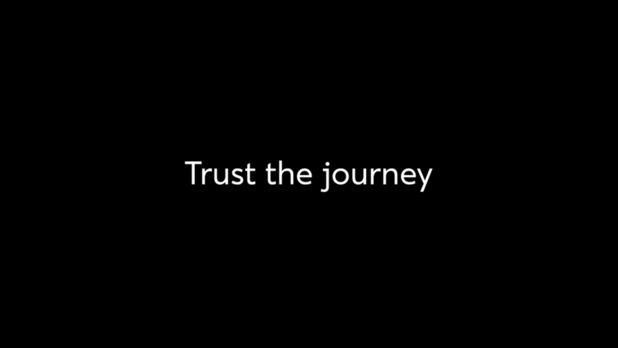 A black background with white text saying Trust the journey