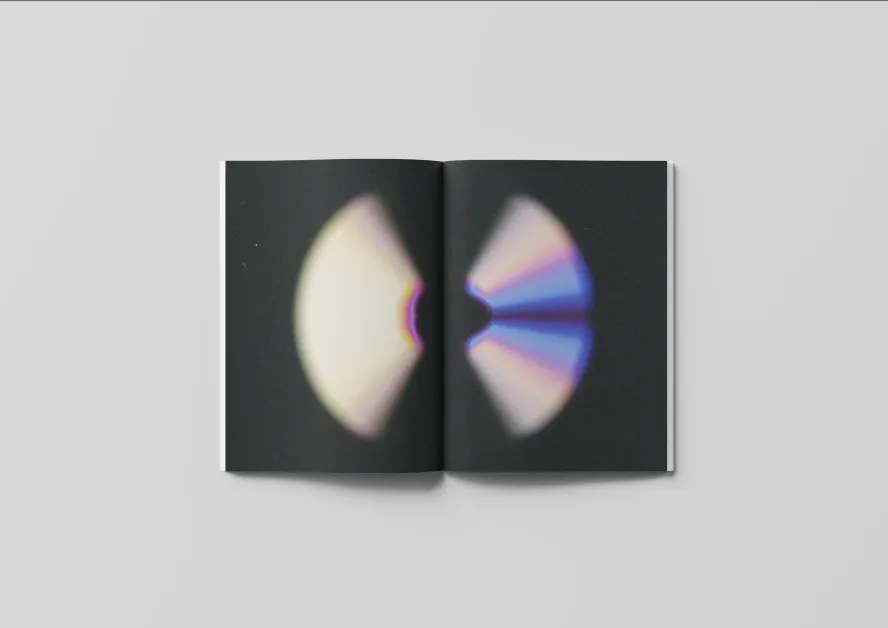 An example of design communication work by Sara Carpiniello. An open book with abstract disc-like shape spanning across the pages. 