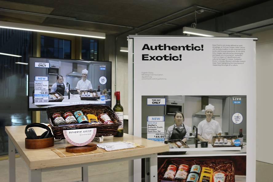A presentation stand presenting design communication student work Authentic Exotic by Eugenie Chung. A table displaying jars of food items with a video and headphones. Next to a banner stand displaying the logo and packaging.