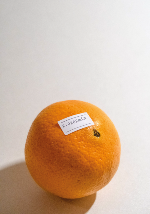 An orange with a "2.020 min" price tag on it.