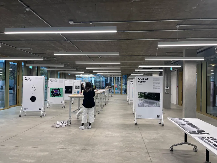  inside the design communication degree show. Students work is neatly lined up on display boards.
