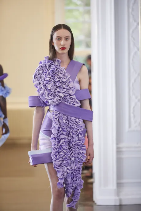 Model wears lavender dress with intricate bunching