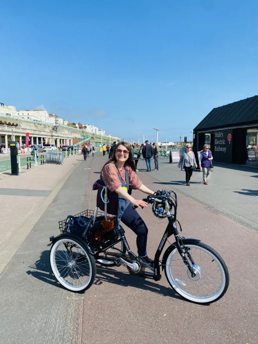 Zara smiles sitting on the hammock seat on a trike