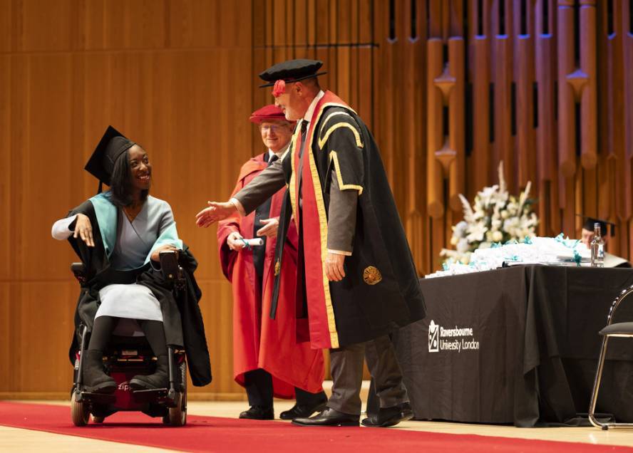 Graduate collects scroll on stage at graduation