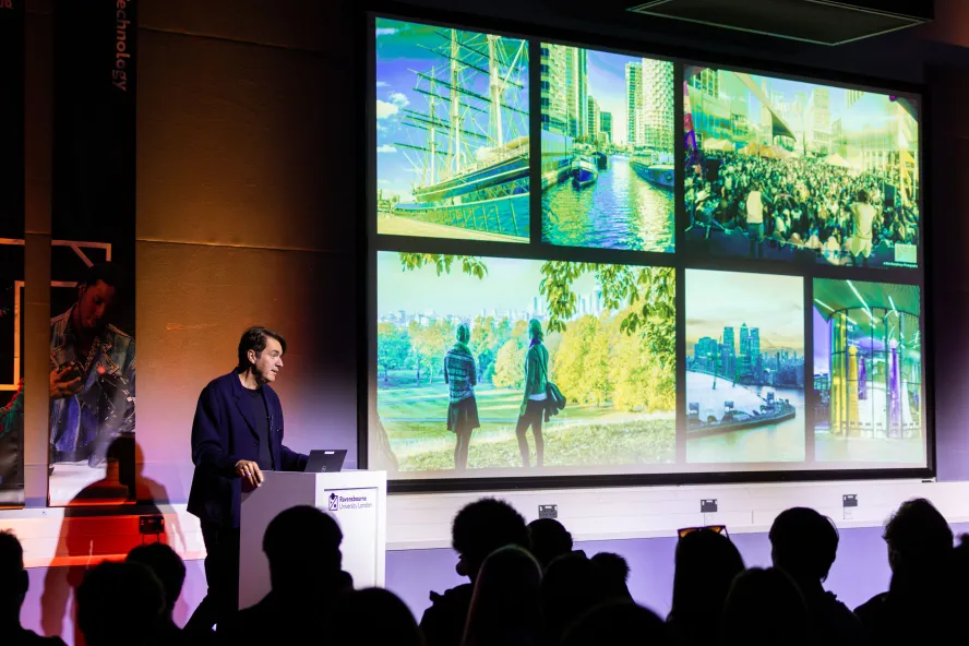 Ravensbourne University's Executive Dean presenting a slideshow with green tint to room of Open Day visitors