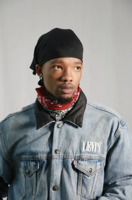 man with hair wrap and bandana staring off into the distance