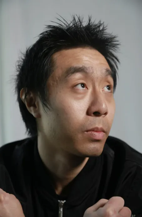 portrait of a man with spiky hair looking off into the distance