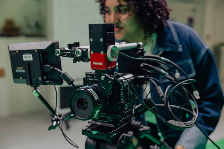 Student looking behind the camera in a digital content creation class