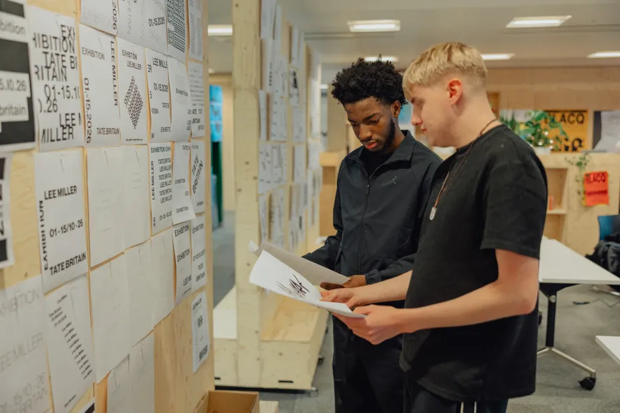 Ravensbourne design students creating a display in their R3 building with student work