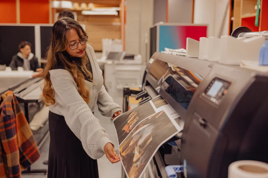 Student printing her work in the print shop