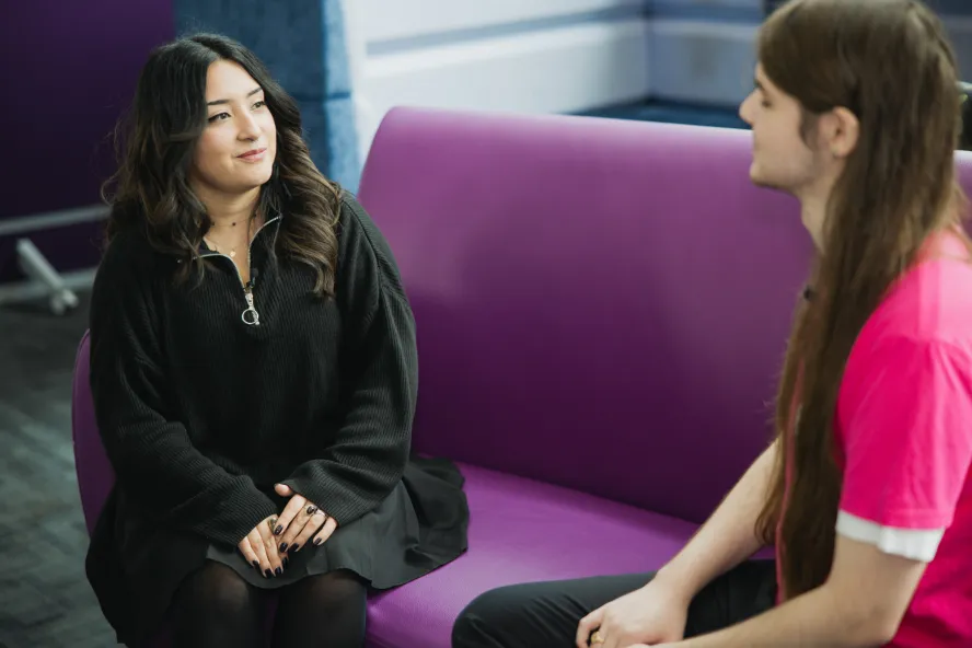 Students talking on sofa in R1 building