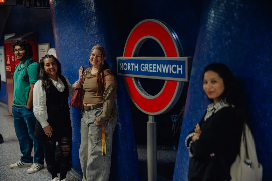 Students posing next to tube station