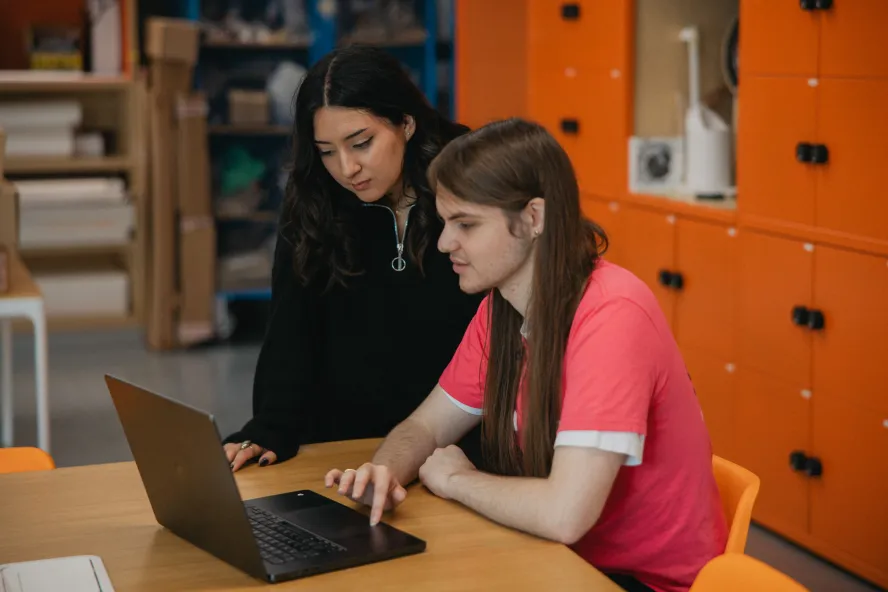 students working on laptop in design classroom