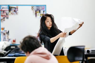 Female student holding up a large piece of paper