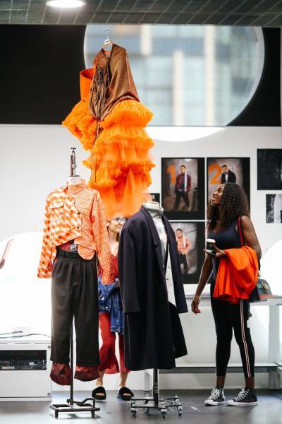woman looks up at display of fashion coursework