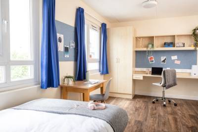 Gold studio room with a bed, table and chairs and two windows