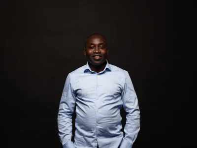 Man in blue shirt smiles at the camera