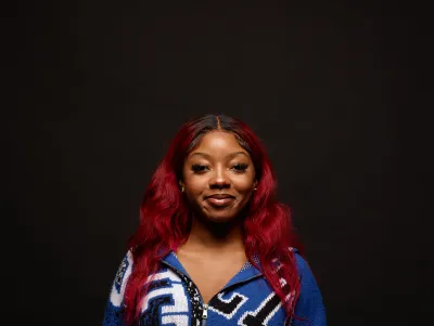 Young woman with red hair smiles to the camera