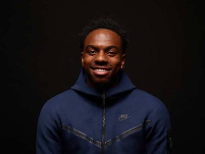 Young man smiling to the camera wearing a Nike Hoodie